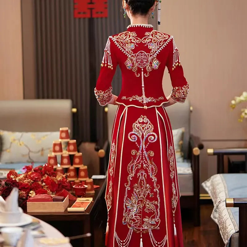 Red embroidered traditional dress worn by a person in an indoor setting.