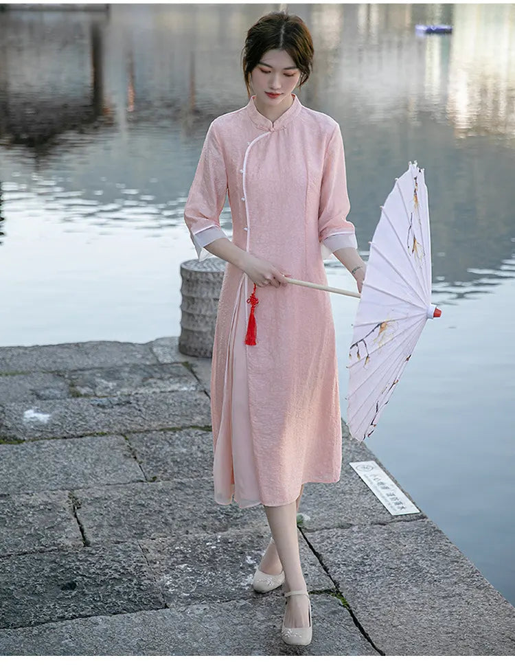Woman in a pink traditional Loose A Line Cheongsam Qipao Dress holding an umbrella by a water body