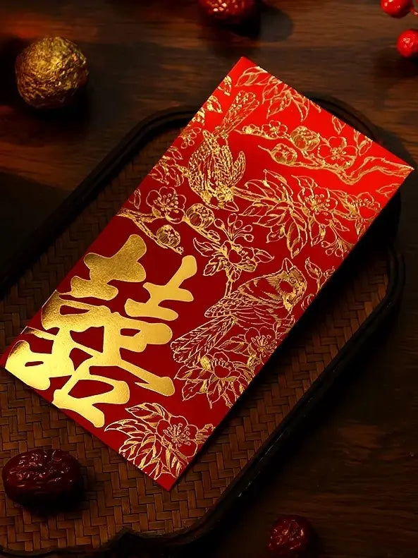 Double happiness wedding red envelope with gold floral patterns and Chinese characters on a wooden surface.