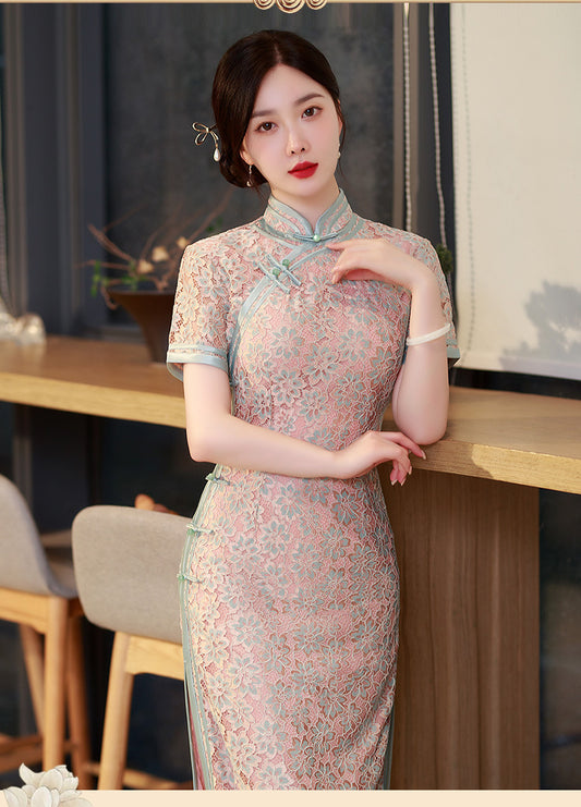 Model in pink lace qipao next to table