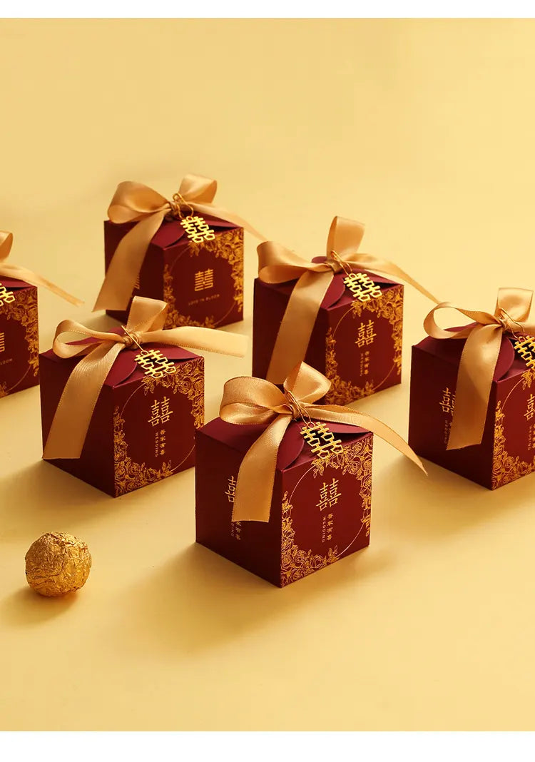 Red & Gold Double Happiness Chinese Wedding Favor Boxes  with gold ribbons on a yellow background