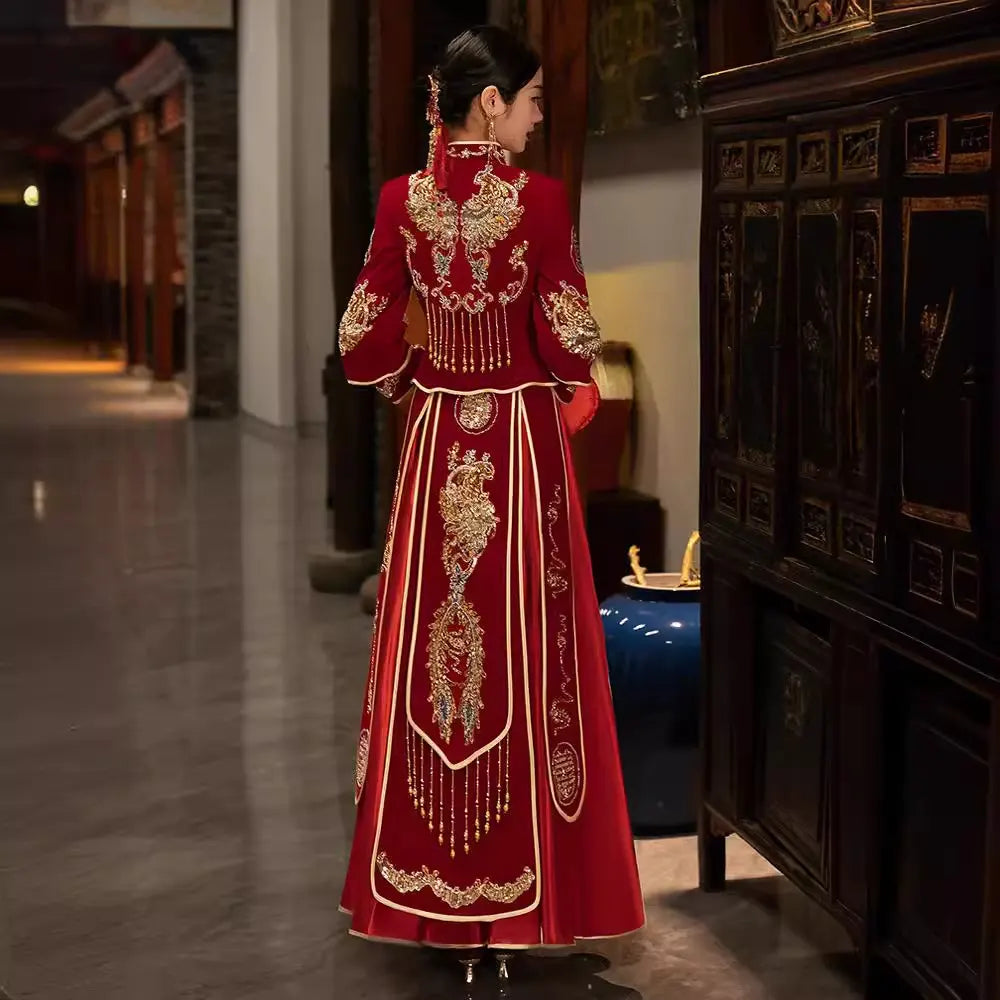 Woman in a Red Qun Kwa – Traditional Chinese Wedding Dress  standing in a dimly lit room.