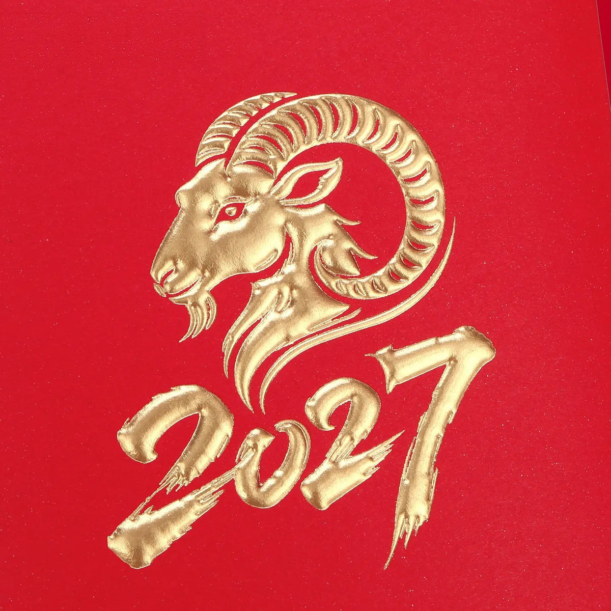A gold foil stamp of a ram's head and the year '2027' on a textured red background, representing the Chinese New Year for the Year of the Ram.