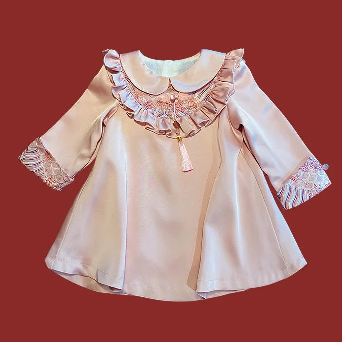 Modern pink Chinese Baby Qipao Cheongsam Dress with Tassel with ruffled collar and long sleeves on a red background