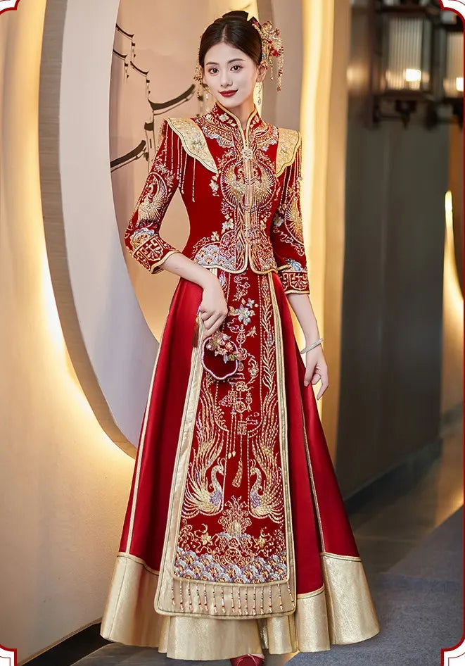 Woman wearing a traditional red and gold embroidered Chinese Velvet Wedding Qun Kwa Dress  indoors.