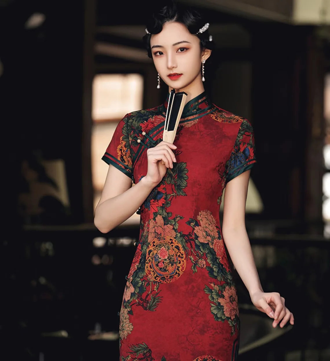 Woman in a Vintage Red Chinese Floral Qipao long Cheongsam Dress  holding a hairbrush against a blurred background