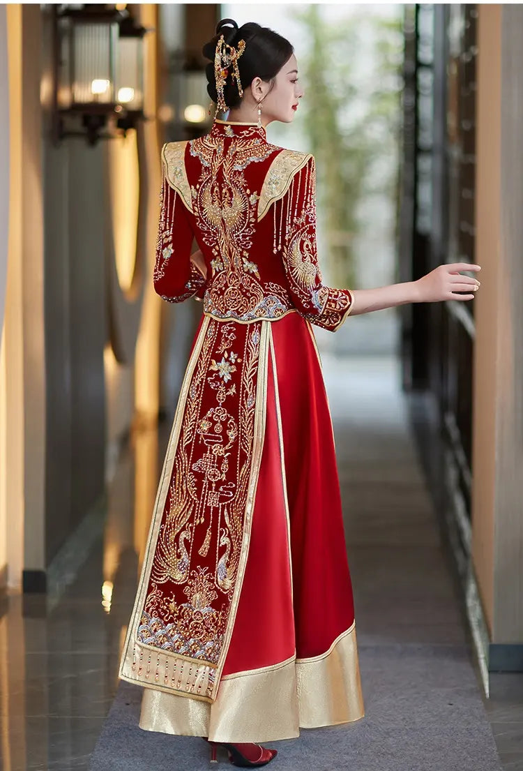 Woman in a traditional red and gold Chinese Velvet Wedding Qun Kwa Dress  standing in a hallway.