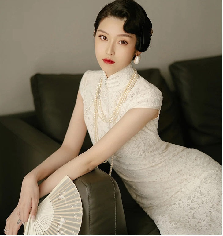 model in traditional chinese white lace cheongsam qipao sitting and looking up