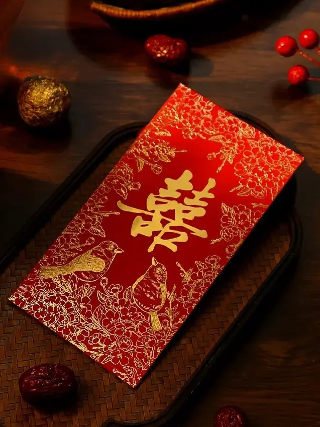 Double happiness wedding Red envelope with gold text and designs on a wooden surface