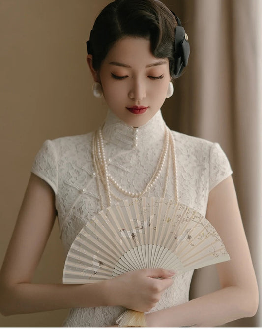 Model in traditional chinese white lace qipao looking down