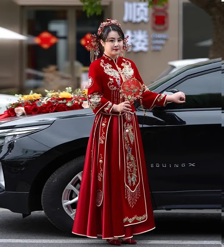Woman in a plus size Red Qun Kwa – Traditional Chinese Wedding Dress standing next to a black SUV with floral decorations.