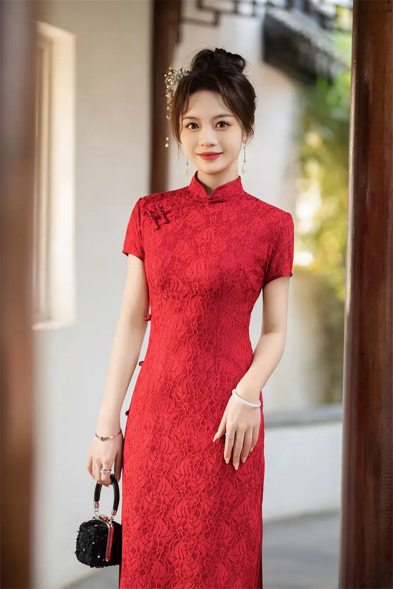 Woman in a Auspicious Red Lace Qi pao  dress standing outdoors with a blurred background