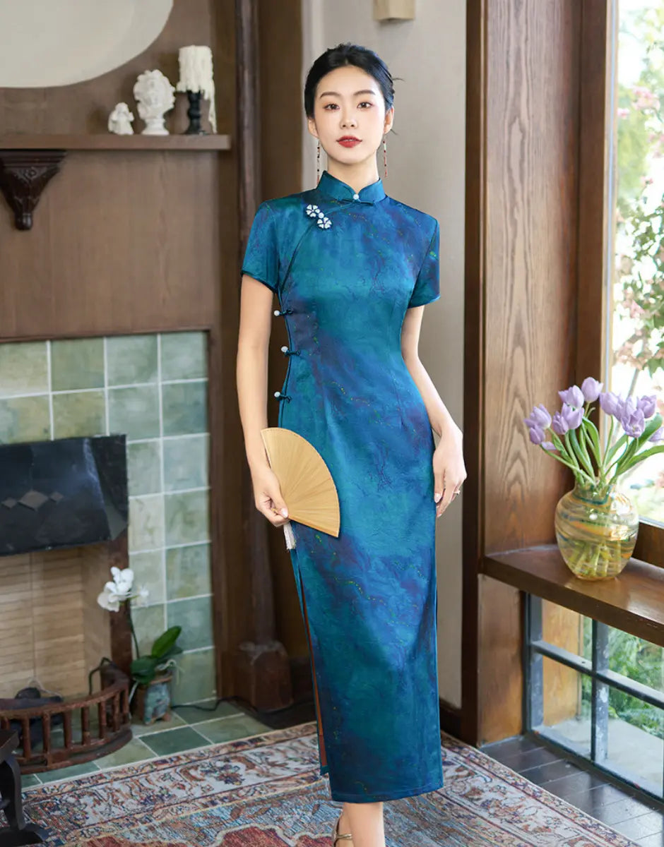 Woman in a Azure Blue Short Sleeve Acetate Satin traditional Chinese Qipao Dress standing in a room with a fireplace and window.