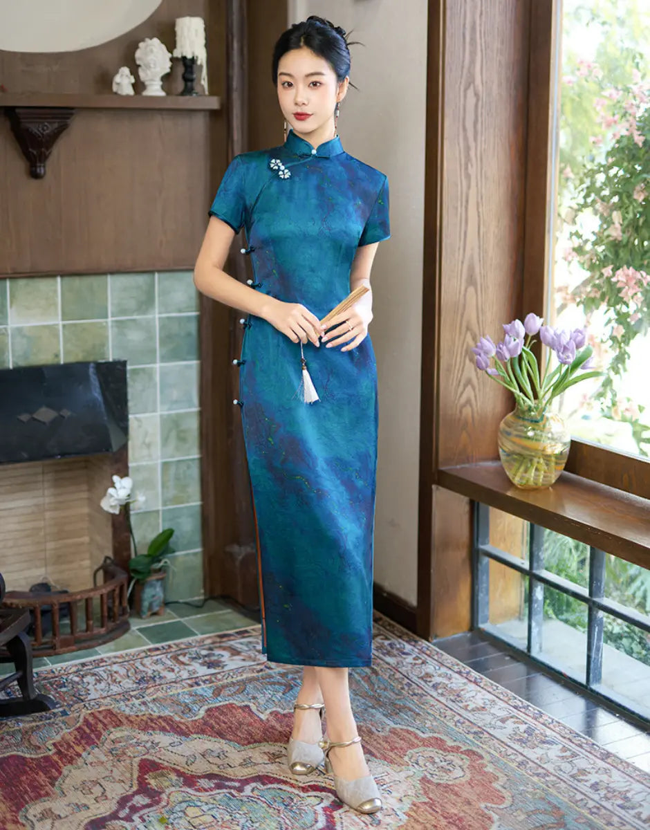 Woman in a Azure Blue Short Sleeve Acetate Satin Qipao Cheongsam Dress standing in a room with a fireplace and window.