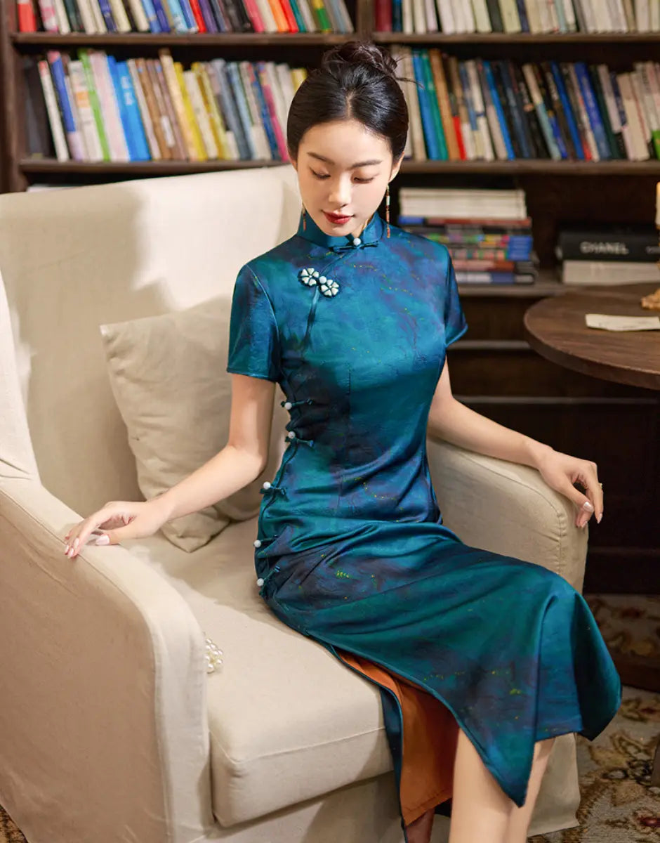 Woman in aAzure Blue Short Sleeve Acetate Satin long cheongsamDress  sitting on a beige armchair with a bookshelf in the background