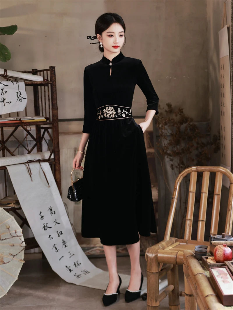 Woman in a  Black 3/4 Long Sleeves A Line Velvet cheongsam Dress with   floral embroidery   in an indoor setting