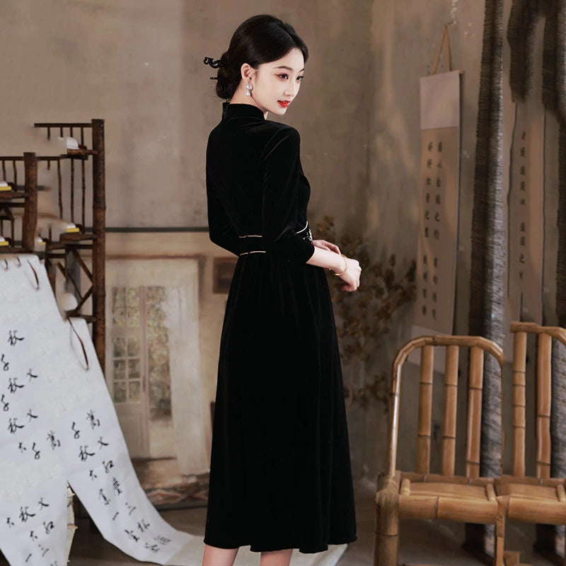 Woman in a Black 3/4 Long Sleeves A Line Velvet Qipao Dress with   floral embroidery  standing in a room with artistic decor