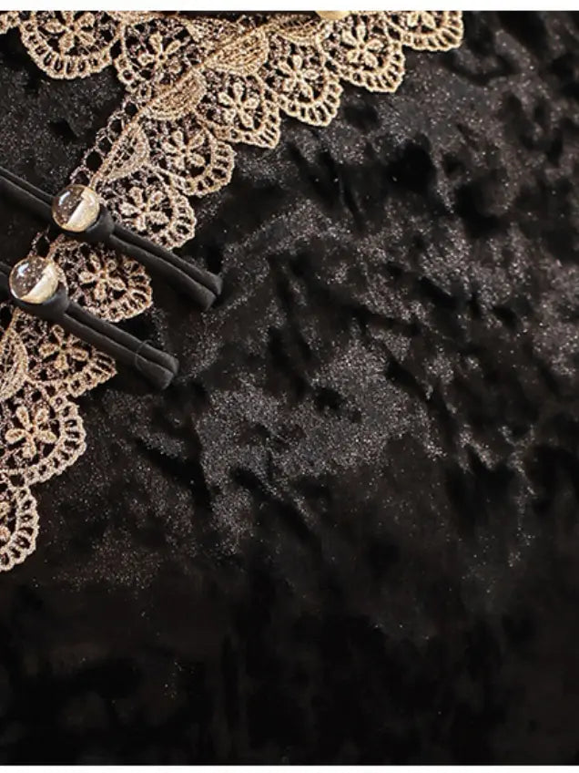 Close-up of a black textured fabric with ornate beige lace trim and black buttons with clear beads.