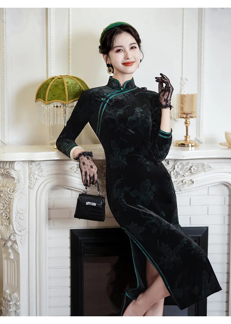 Woman in a Black & Emerald Green Velvet Long Sleeves Qipao Dresssitting on a white fireplace mantle.