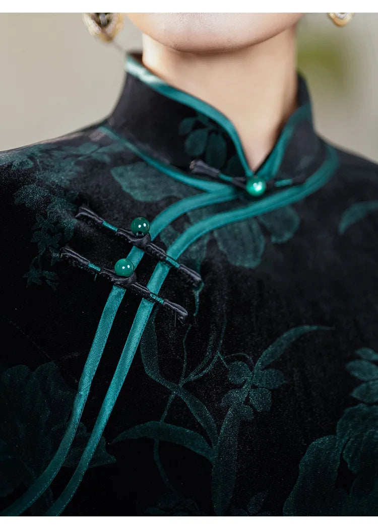 Close-up of a traditional chinese garment with green embroidery and buttons.