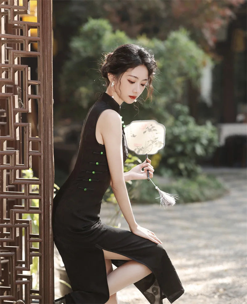 Woman in a Black Floral Jacquard Sleeveless Qipao Cheongsam Dress  holding a floral fan in a garden setting