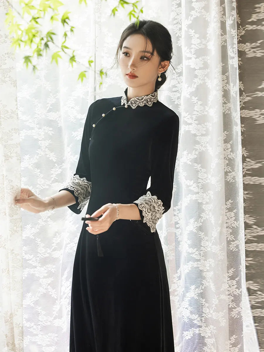 Woman wearing a Black Long Sleeves Velvet A-Line Qipao with Lace Trim  in front of a white curtain.