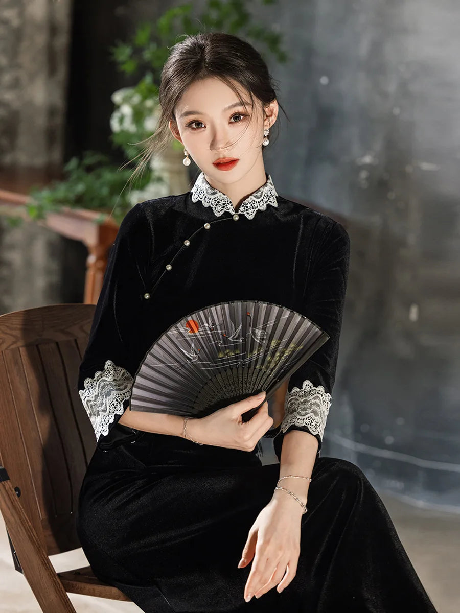 Woman in a black traditional outfit  Long Sleeves Velvet A-Line Qipao with Lace Trimholding a fan against a blurred indoor background