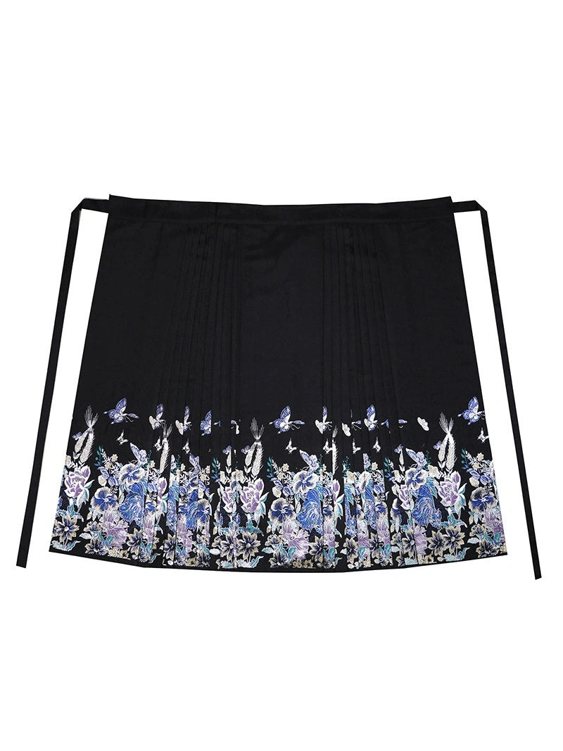 A black pleated chinese ming dynasty mamian skirt with a decorative floral and bird pattern along the bottom hem, featuring two side ties, shown against a plain white background.