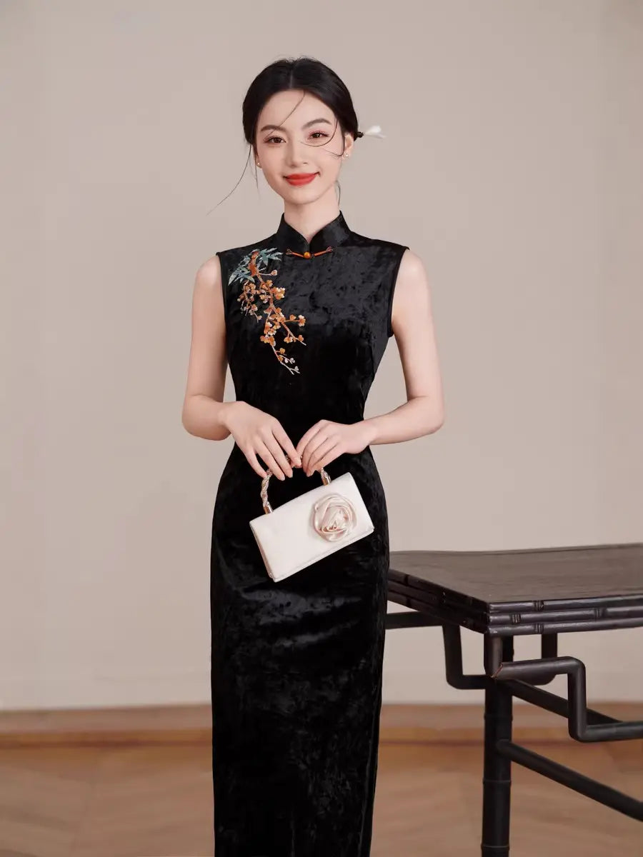 Woman in a Black Modern Velvet Sleeveless Embroidered Qipao cheongsam dress holding a white handbag in a minimalistic setting.