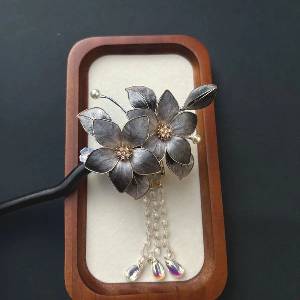 Black Sandalwood Ronghua Velvet Flower Hair Stick with Tassel on a wooden stand against a dark background
