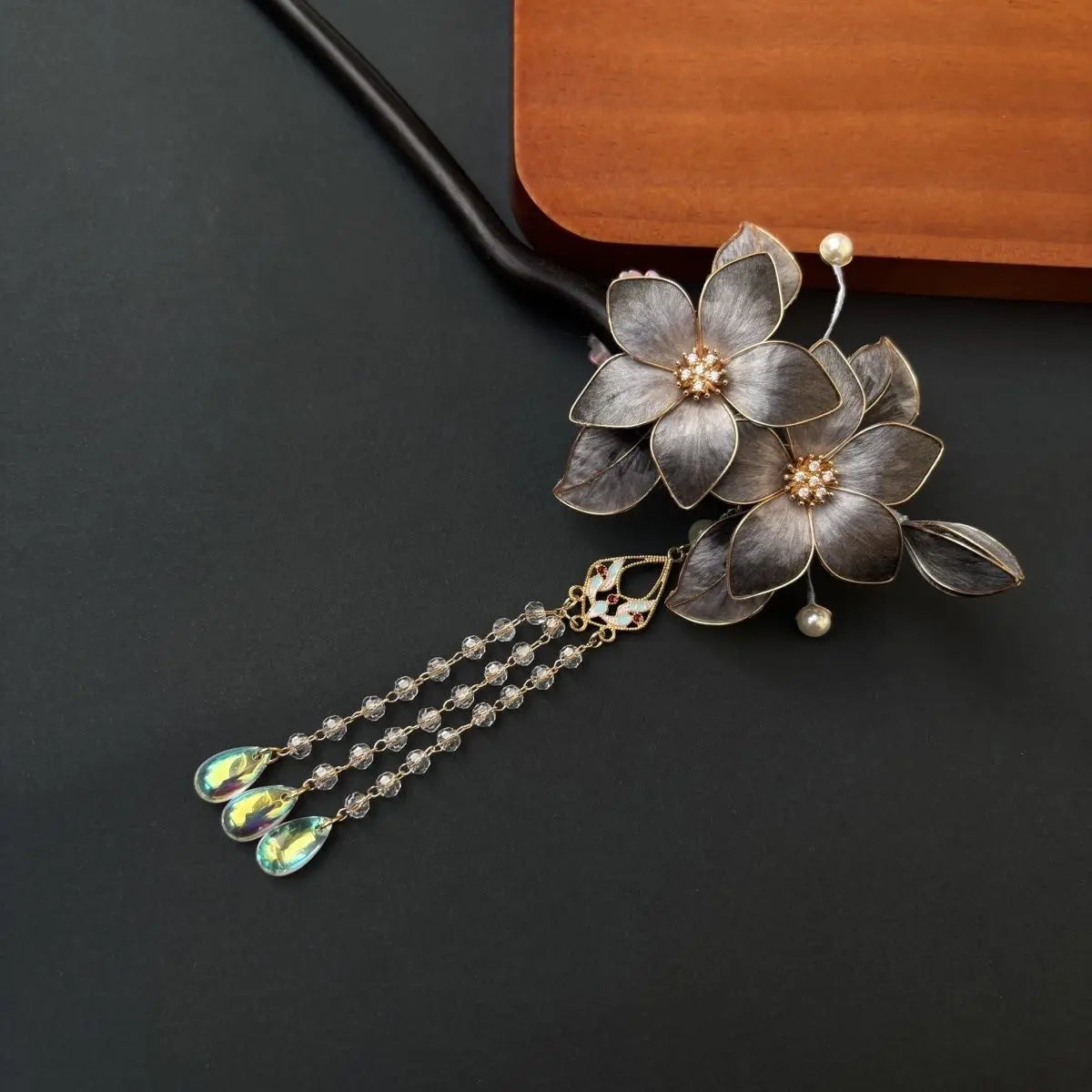 Black Sandalwood Ronghua Velvet Flower Hair Stick with Tassel on a dark background