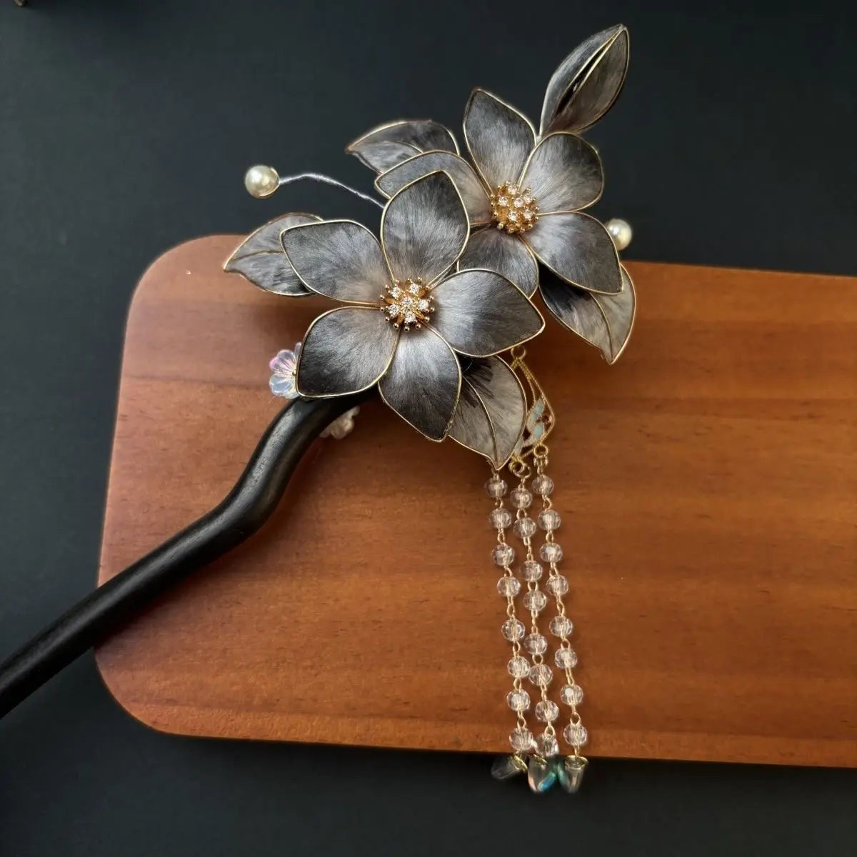 Black Sandalwood Ronghua Velvet Flower Hair Stick with Tassel on a wooden block