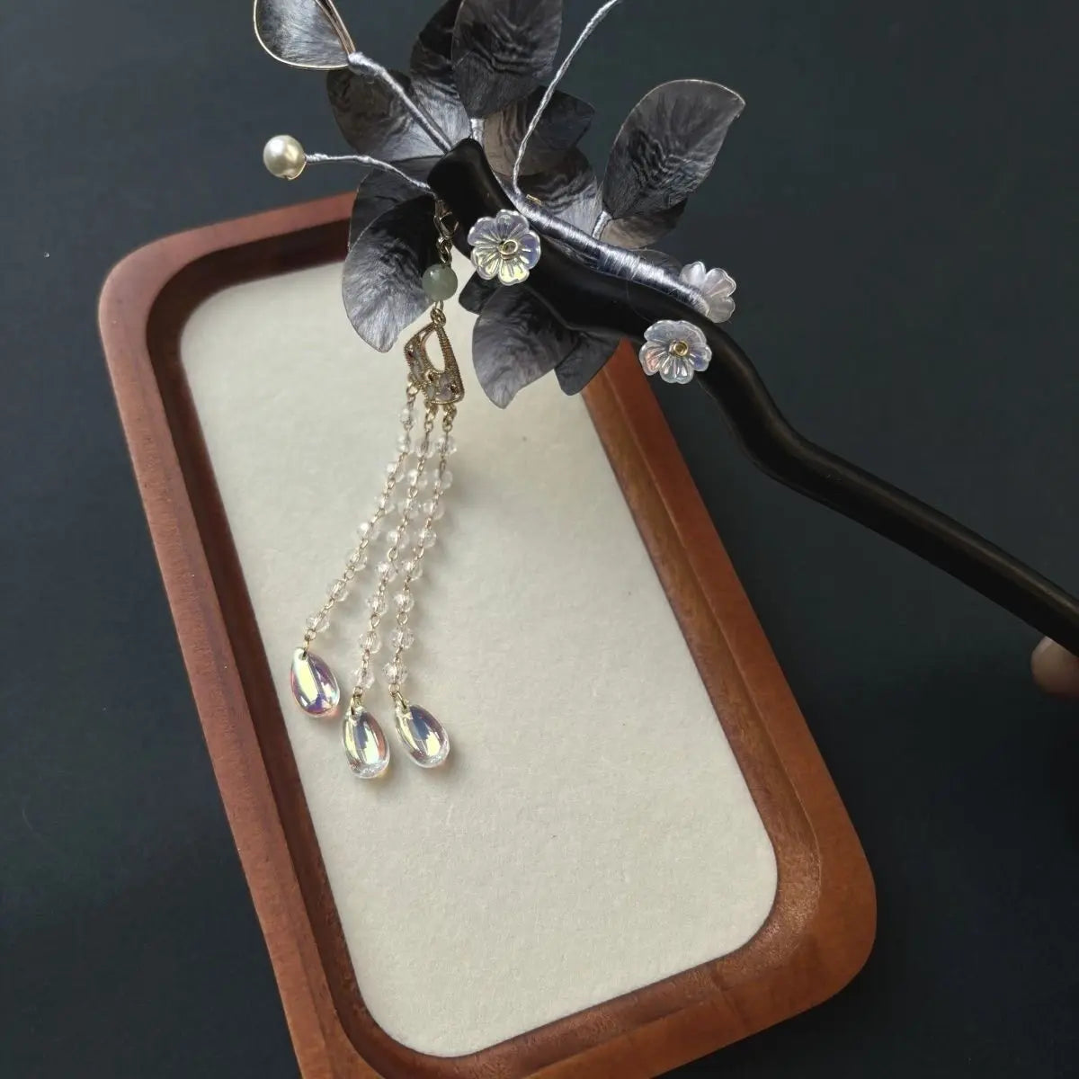 Black Sandalwood Ronghua Velvet Flower Hair Stick with Tassel and dangling beads on a dark background