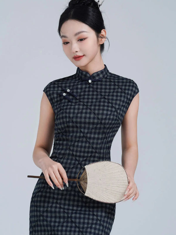 Woman in a Black Vintage Plaid Modern Cap Sleeve Qipao Dress dress holding a fan against a plain background