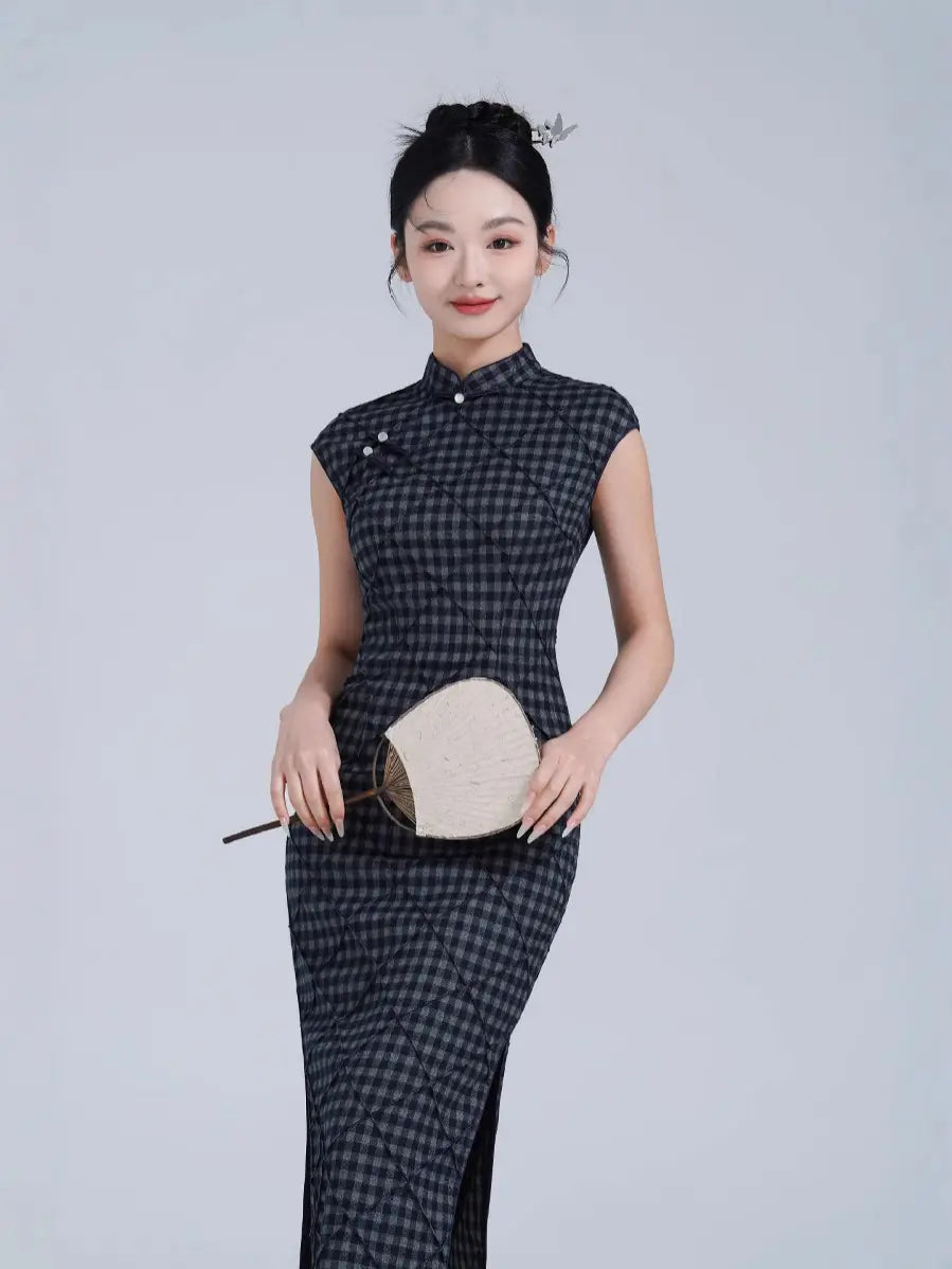 Woman wearing a Black Vintage Plaid Modern Cap Sleeve Qipao Dress  with a white clutch against a light gray background