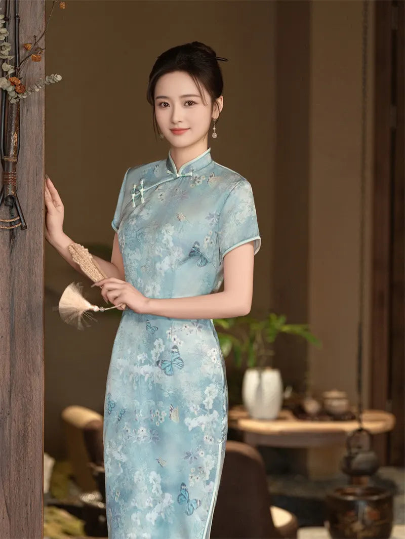 Woman in a light  Blue Floral Cheongsam Qipao Dress standing in a room with a blurred background