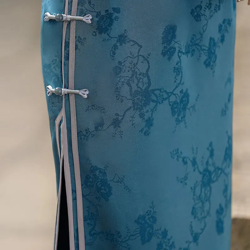 Blue fabric with floral pattern and silver buttons on a beige background