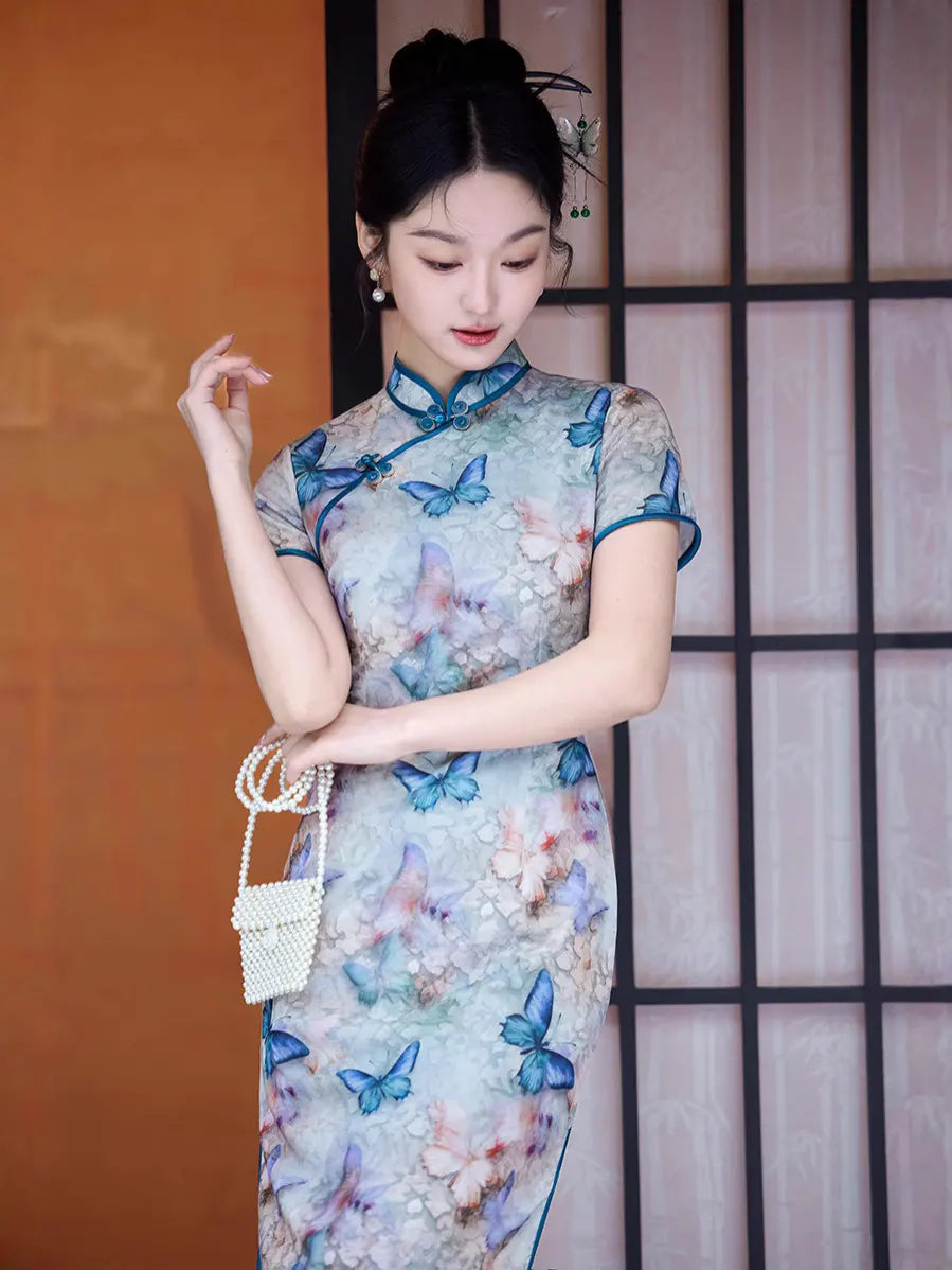 Woman wearing a Blue Midi Length Qipao Dress with Butterfly and Floral Print  with butterfly patterns in a room with an orange wall and wooden lattice.