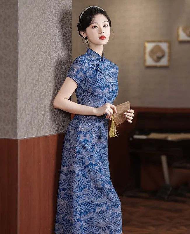 Woman in a Blue Short Sleeves patterned  A-Line Qipao Dress  holding a fan indoors.