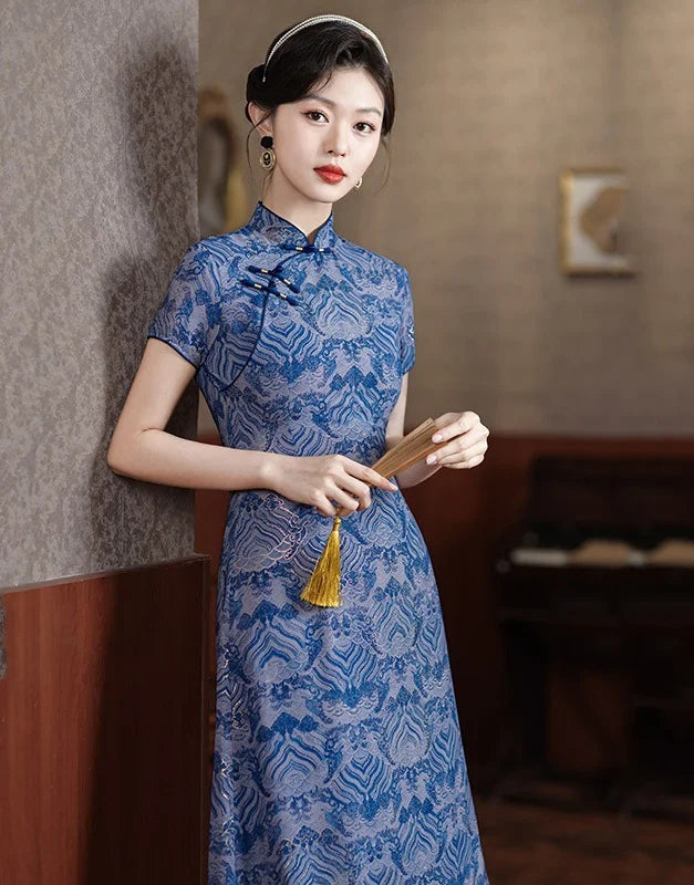Woman in a Blue Short Sleeves patterned  A-Line Qipao Dress holding a fan indoors.