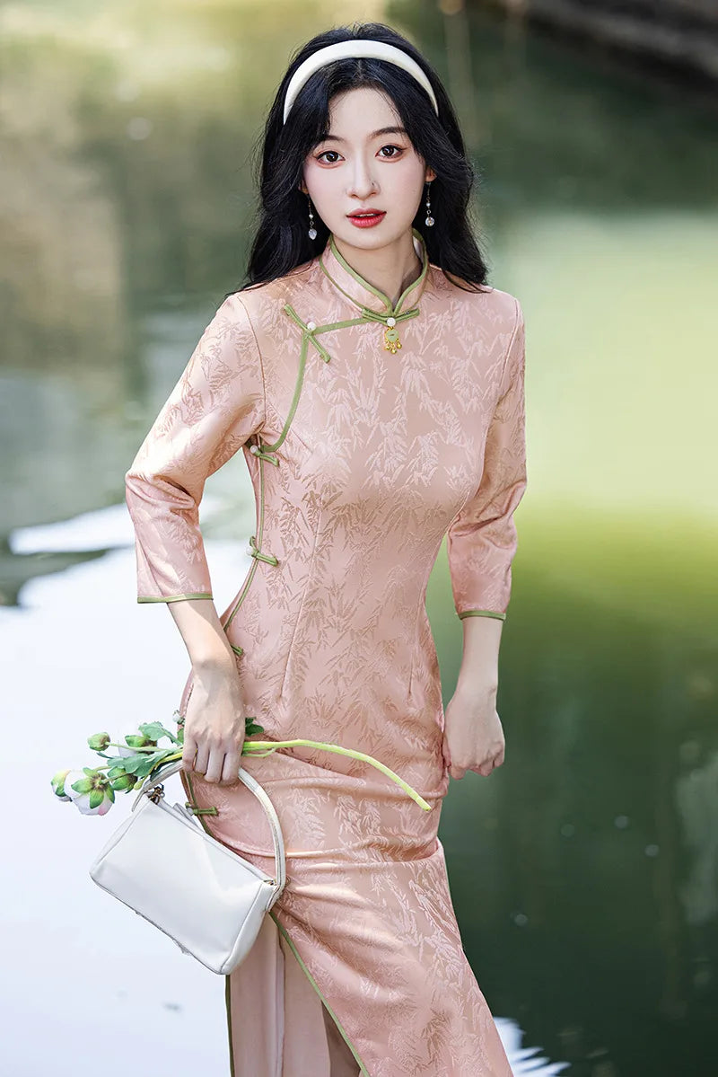 Woman in a traditional Blush Pink Long Sleeves Qipao Cheongsam Dress with Bamboo Pattern outfit standing by a body of water.