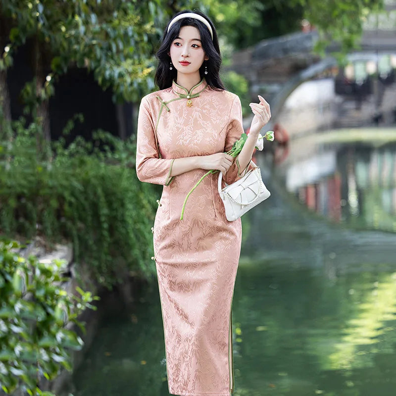 Woman in a Blush Pink Long Sleeves Qi pao Cheongsam Dress with Bamboo Pattern  standing by a body of water with greenery
