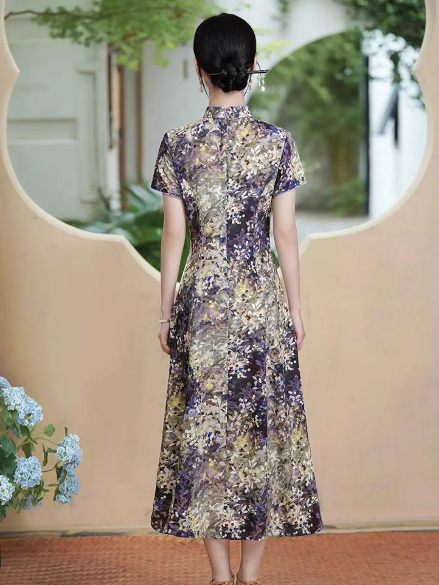 A woman viewed from behind wearing a short-sleeved Botanical Violet & Olive Floral Jacquard Modern A Line Qipao  cheongsam dress with a purple, gold, and beige floral pattern. She is standing in front of a beige wall with a decorative archway and greenery in the background.