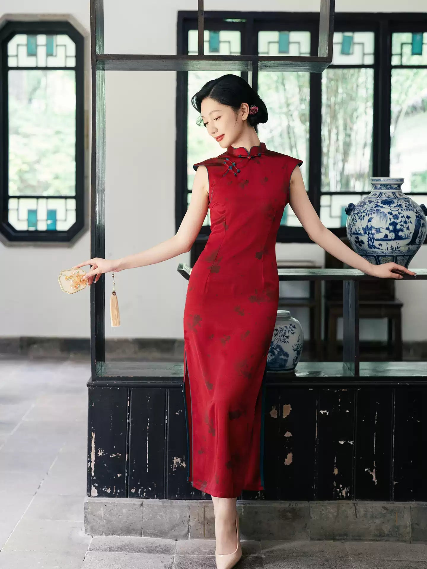 Woman in a Crimson Red Sleeveless Goldfish Qipao cheongsam Dress  standing in a room with traditional decor