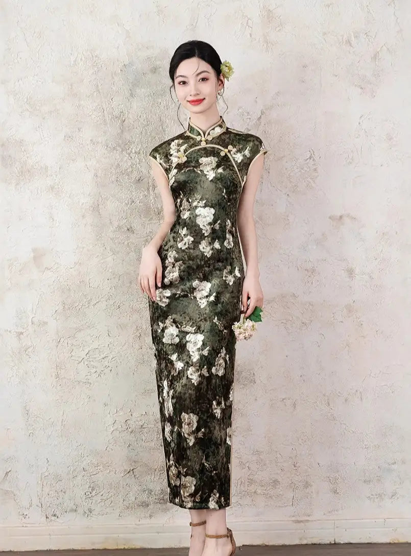 Woman wearing a Dark Green Foral Velvet Cap Sleeves Long Qi pao Dress  against a textured wall