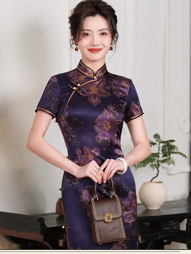Woman wearing aDeep Amethyst Purple & Gold Floral Silk Long Qipao  dress holding a brown handbag indoors.