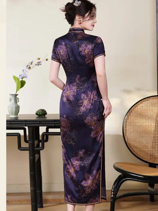 Woman wearing a Deep Amethyst Purple & Gold Floral Silk Long Qipao cheongsam dress in a room with a table and chair.