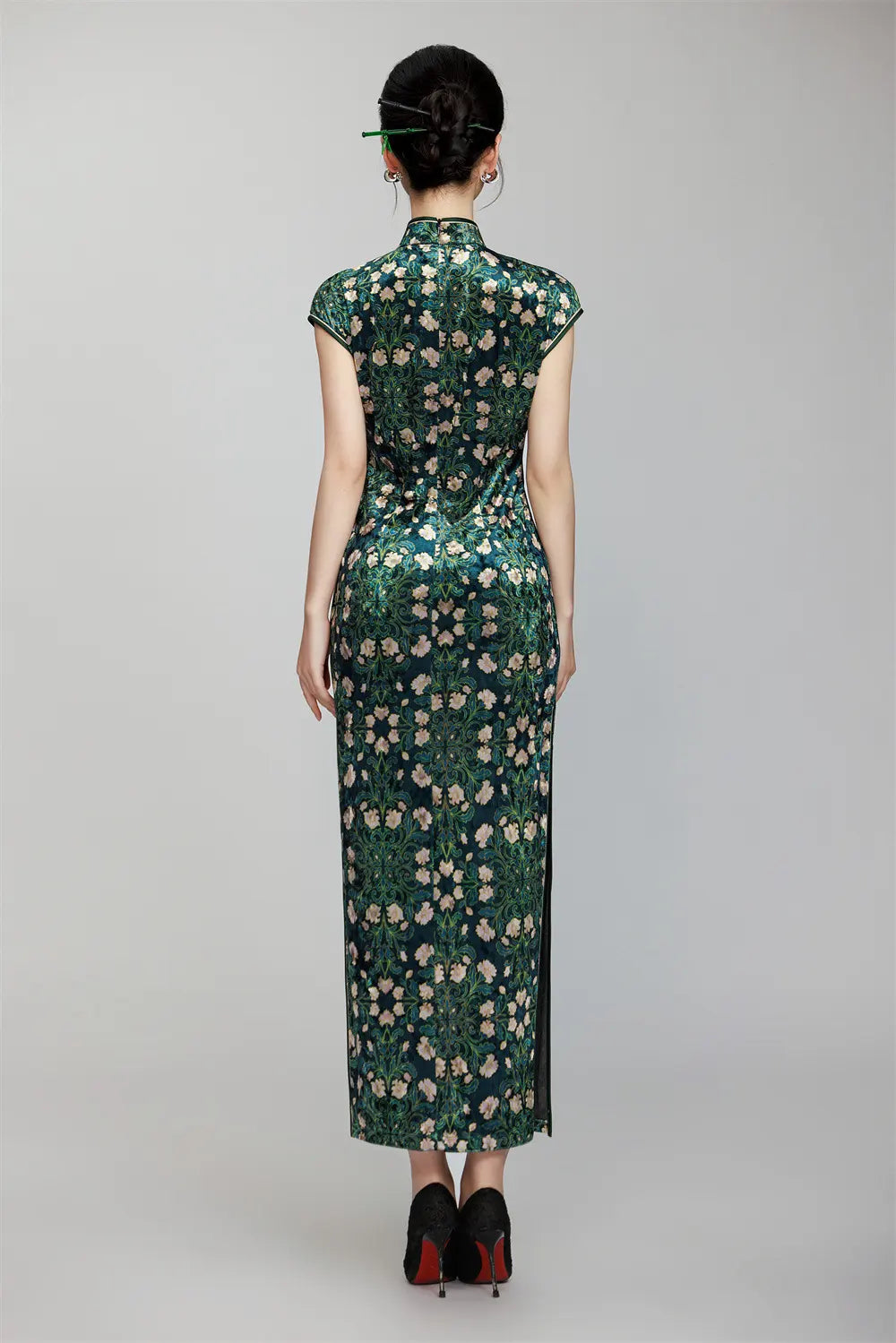 Woman wearing a Deep Green Floral Cap Sleeves Long Qipao Dress with a plain background