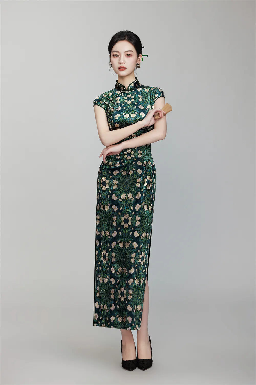Woman wearing a Deep Green Floral Cap Sleeves Long Qipao Dress on a gray background