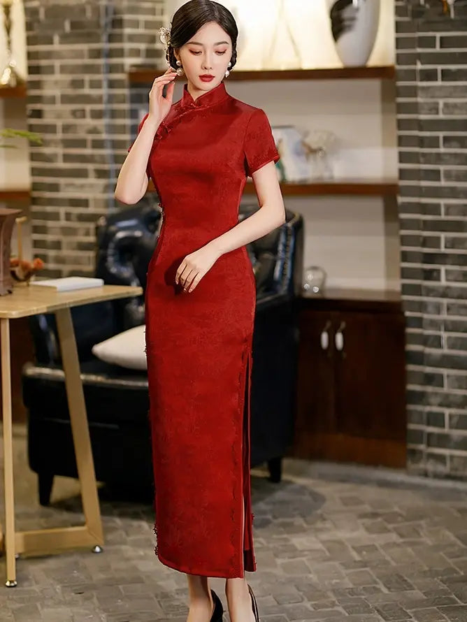 Woman wearing a Deep Red Floral Long Qipao Cheongsam Dress with Lace Trim in an indoor setting with a brick wall background